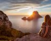 Woman back to the front watching a beautiful sunset at the beach. The beach is called Es Vedra, in Ibiza and belongs to balearic islands, in Spain